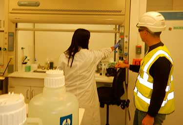 Certified Industrial Hygienist (CIH) evaluating a fume hood face velocity at a fuels laboratory in Okinawa, Japan