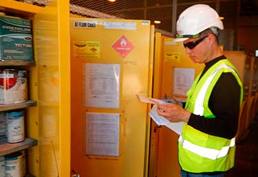 Certified Industrial Hygienist (CIH) evaluating a HAZMAT cabinet in Okinawa, Japan