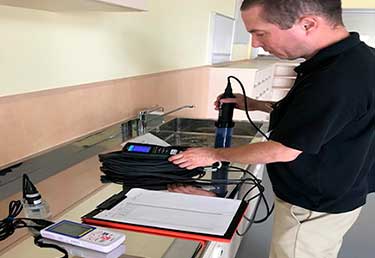 Environmental engineer sampling water in building in MCAS IWakuni, Japan