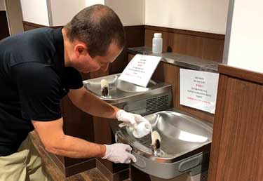 Environmental engineer sampling water in building in MCAS IWakuni, Japan