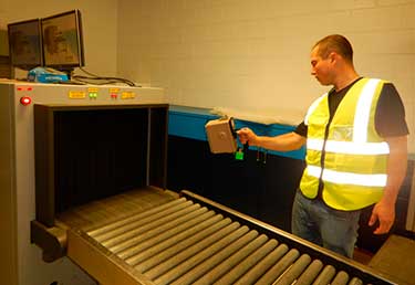 Certified Industrial Hygienist (CIH) measuring ionizing radiation at a X-Ray machine in a conveyor belt at an airport in a military base in Okinawa, Japan
